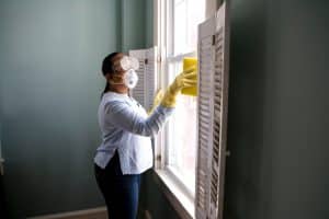 femme de ménage avec des équipements de protection pour nettoyer des vitres